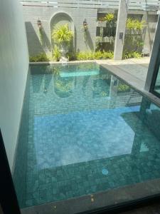 een zwembad met een tegelvloer en een raam bij villa kamala regent 2 bedrooms in Kamala Beach