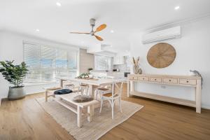 eine weiße Küche mit einem Esstisch und Stühlen in der Unterkunft Blanc 1 in Crescent Head