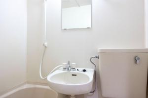 a white bathroom with a sink and a mirror at Winbell Solo Higashi-kamata in Tokyo
