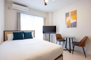 a bedroom with a bed and a table with chairs at Winbell Solo Higashi-kamata in Tokyo +38 photos