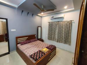 a bedroom with a bed and a ceiling fan at Providence homestay malpe in Udupi