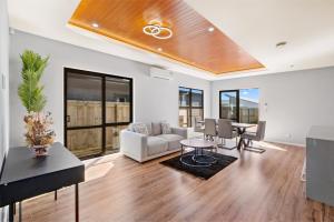 a living room with a couch and a table at Beach Revival - Clarks Beach Holiday Home in Clarks Beach