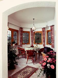 a dining room with a table and chairs and windows at Café Pension Waldfrieden in Bad Peterstal-Griesbach