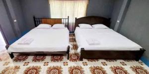 two beds sitting next to each other in a bedroom at DoiLom Farmstay in Ban Muang Kut +4 photos