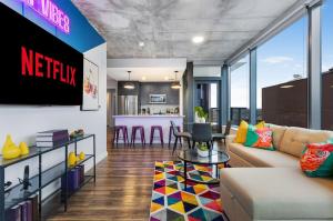 a living room with a television and a kitchen at The Urban Kaleidoscope Downtown Nashville in Nashville