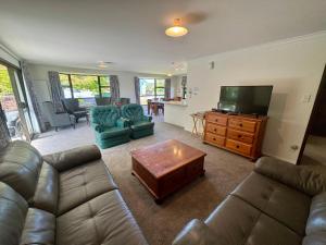 een woonkamer met een bank en een flatscreen-tv bij 66 Conical Hill Road in Hanmer Springs