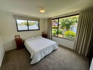 een slaapkamer met een bed en een groot raam bij 66 Conical Hill Road in Hanmer Springs