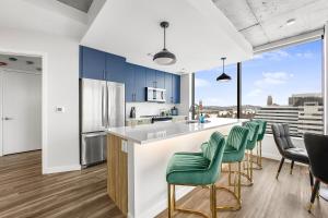 a kitchen with blue cabinets and green chairs at Wild & Chic Safari Suite Downtown Nashville in Nashville