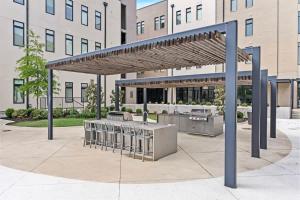 a patio with a grill and bar with stools at Pinnacle Heights 2Bdrm 3rd flr Near Walmart Amp Pool Fitness Center Yoga Studio Dog Spa in Rogers
