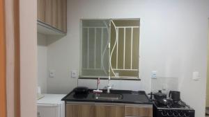 a kitchen with a sink and a stove at Residencial SC in Manaus +1 photo