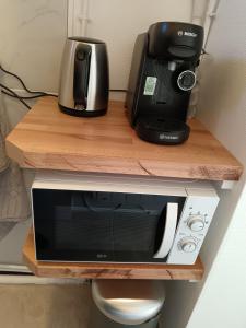 microondas y cafetera en un estante en Séduisant studio confortable, en Orléans