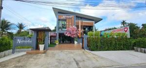 a small house with a sign on the front of it at Natnicha Pool Villa Hatyai in Ban Nam Noi