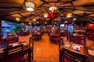 an empty restaurant with tables and chairs and lights at Villa Bali Eco Resort, Rayong in Rayong