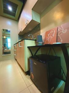 a kitchen with a counter with a tv in it at Condo Unit at Symphony Towers, Timog, Quezon City in Manila +7 photos
