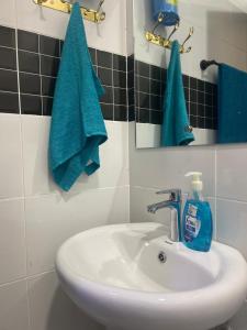 a bathroom sink with a mirror and a blue towel at Mombasa Apartments in Mombasa