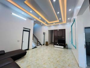 a living room with a couch and a television in it at Xa Ly Villa Mộc Châu in Mộc Châu