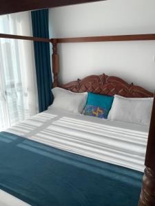 En eller flere senge i et værelse på Mombasa Apartments