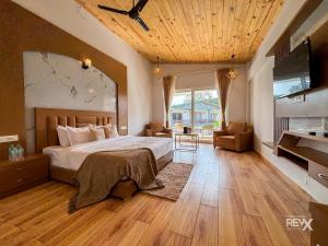 a bedroom with a large bed with a wooden ceiling at Wonderwood Corbett Resort -1min walk to River with Deep Jungle Trail in Rāmnagar