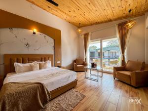 una camera da letto con un letto, un divano e una sedia di Wonderwood Corbett Resort -1min walk to River with Deep Jungle Trail a Ramnagar