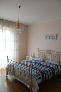 sypialnia z dużym łóżkiem i żyrandolem w obiekcie B&B Da Roby w mieście Corinaldo