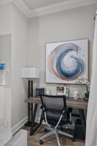 a desk with a chair in a room with a painting at Zen House, a peaceful sanctuary in Shreveport, LA! Tv in each room in Shreveport