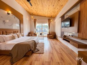 a bedroom with a bed and a flat screen tv at Wonderwood Corbett Resort -1min walk to River with Deep Jungle Trail in Rāmnagar +53 photos