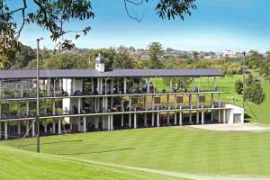 a large building with a green field in front of it at Close to Light Rail UNSW Centennial Park Beach Free Parking in Sydney