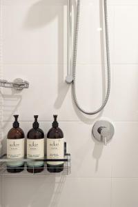 three bottles of soap sitting on a shelf in a bathroom at Close to Light Rail UNSW Centennial Park Beach Free Parking in Sydney