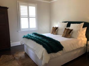 una camera da letto con un letto con una coperta verde sopra di Belmore Cottage - Historic home in Central South ad Armidale