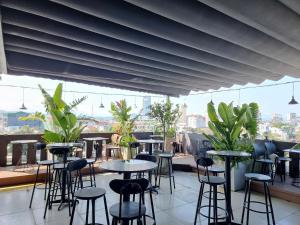 a row of tables and stools on a rooftop with plants at Royal Homestay And Coffee in Thôn Lại Thê
