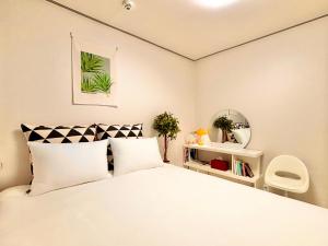 ソウルにあるLucky7Houseの白いベッドと鏡のある寝室