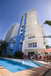 a building with a swimming pool in front of a building at Myconos Resort in Maroochydore