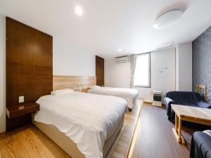 a hotel room with two beds and a desk at Tabist Diversity Hotel Sin Tokiwa Asahikawa in Asahikawa