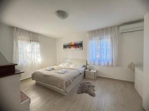 um quarto branco com uma cama e uma janela em Flowers Apartments Medulin, Fucane 2 em Medulin