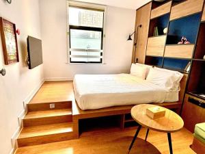 a small room with a bed and a table at Campanile Shanghai Huaihai in Shanghai