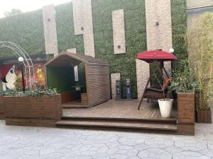 a wooden deck with a gazebo in front of a building at Campanile Shanghai Huaihai in Shanghai