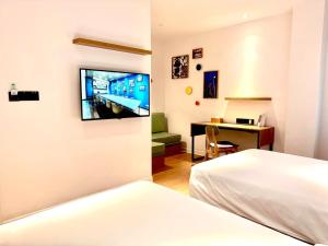 a hotel room with a bed and a tv on the wall at Campanile Shanghai Huaihai in Shanghai