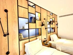 a bedroom with two beds and a wall with mirrors at Campanile Shanghai Huaihai in Shanghai