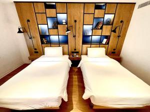 two beds in a room with mirrors on the wall at Campanile Shanghai Huaihai in Shanghai