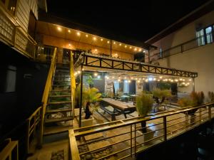 ein Gebäude mit einer Terrasse mit Tischen und Lampen in der Unterkunft Himori homestay & coffee in Ấp Kim Thạch