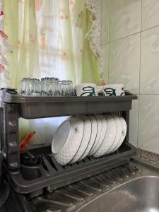 Un estante con platos y tazas en una cocina en Home sweet Home, en Thika