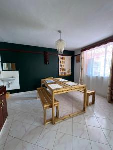 comedor con mesa de madera y banco en Home sweet Home, en Thika