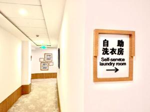 a hallway in a hospital with a sign on a wall at Campanile Shanghai Huaihai in Shanghai