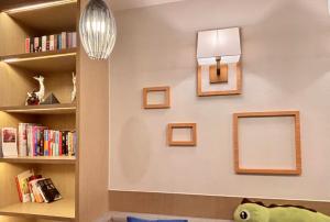 a room with bookshelves and a clock on a wall at Campanile Shanghai Huaihai in Shanghai