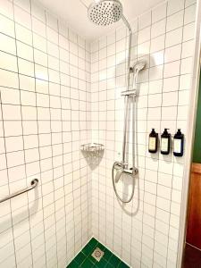 a shower in a white tiled bathroom with a green floor at Campanile Shanghai Huaihai in Shanghai