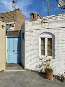 a brick building with a blue door and a window at Mariz unique studio in Cairo