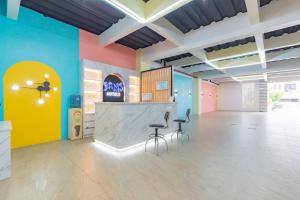 a room with two stools in a room with colorful walls at Sans Hotel Sky Home Syariah Tegal in Tegal