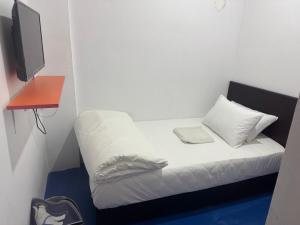 a small room with a bed with a tv on it at H Budget Hotel in Johor Bahru +2 photos