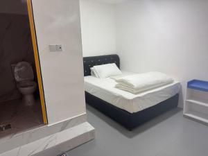 a small bedroom with a bed and a mirror at H Budget Hotel in Johor Bahru