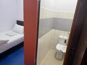 a small bathroom with a toilet and a bed at H Budget Hotel in Johor Bahru